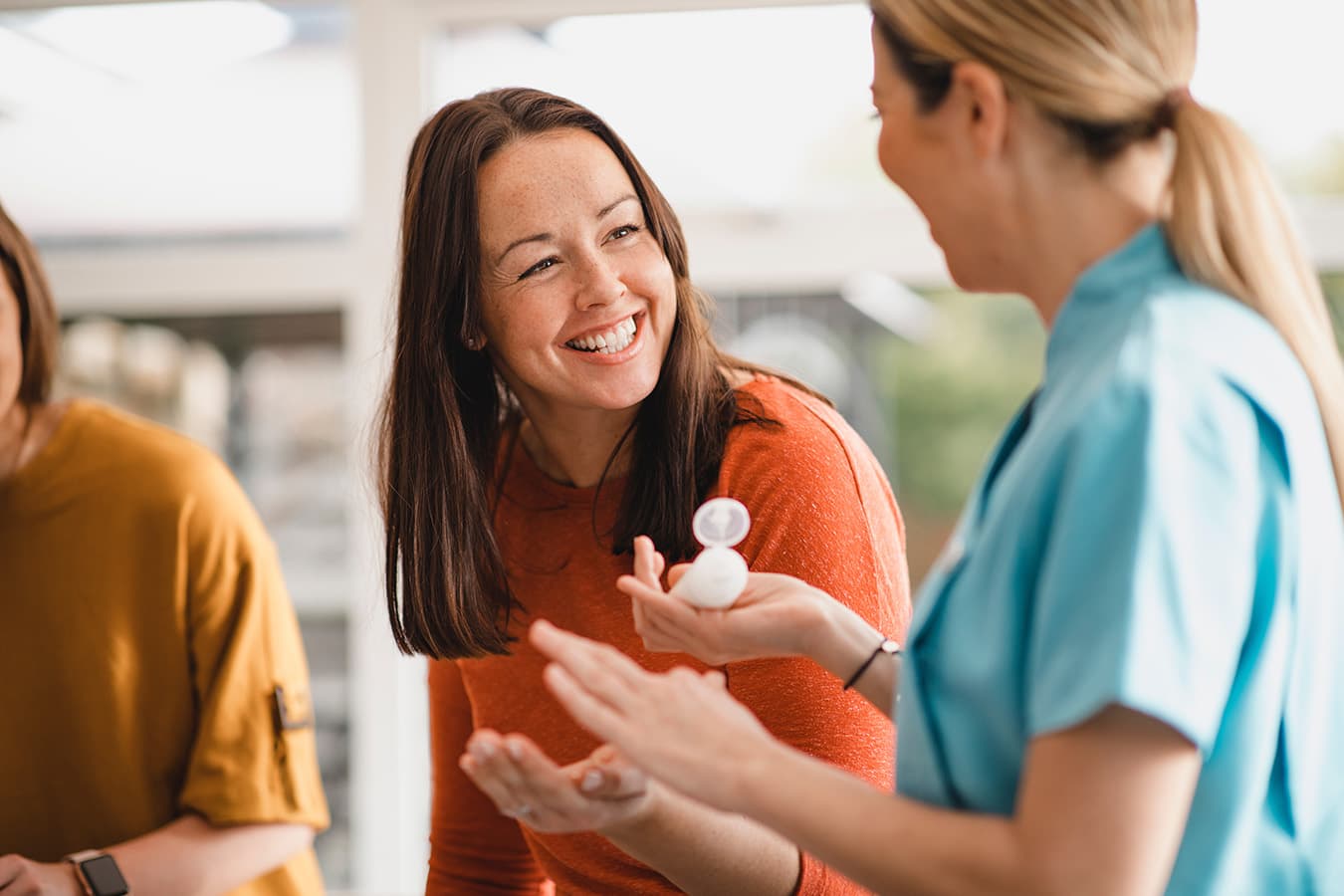 Store staff helping a happy customer try a cream, a great in-store experience