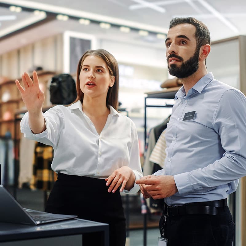 Store manager giving a sales associate instructions on what needs to be done before the next campaign and display change.