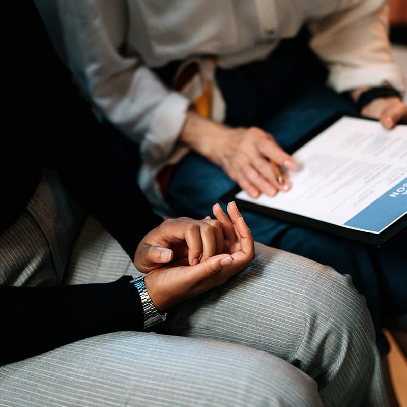 Two people sitting next to each other, one pointing at a line on the other's CV.