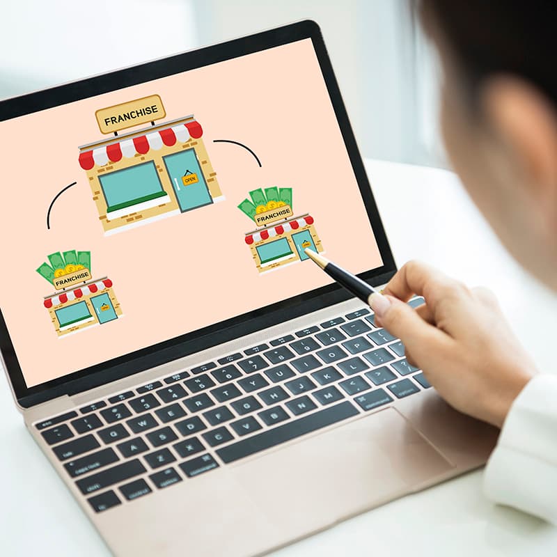 A woman goes through a franchise introduction training on a laptop.